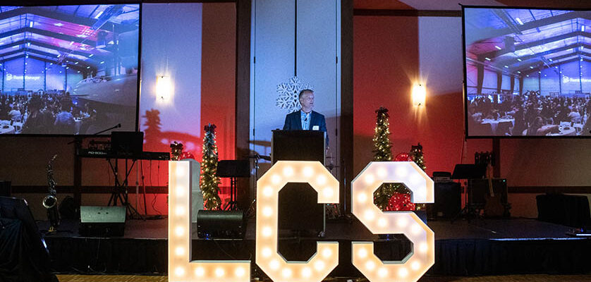 Man speaking at podium in front of LCS sign