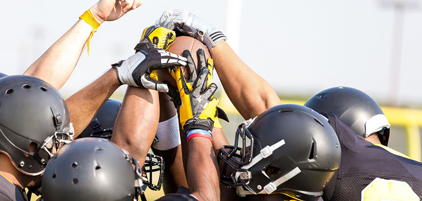 Professional Football players celebrate their championship team with a huddle