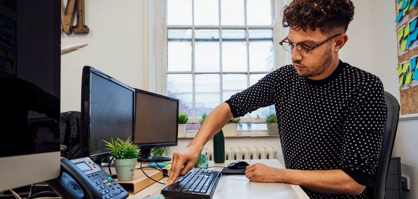 A man cleaning his desk to improve mental health benefits of a clean workspace